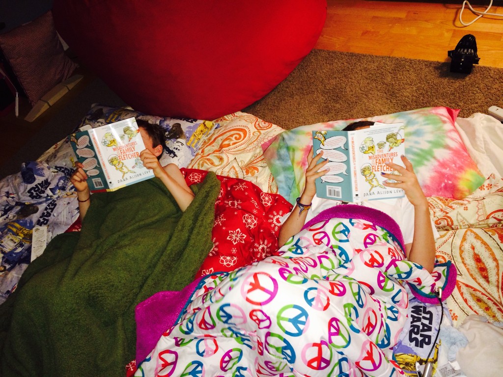 Two readers back at home, camped out with their new books
